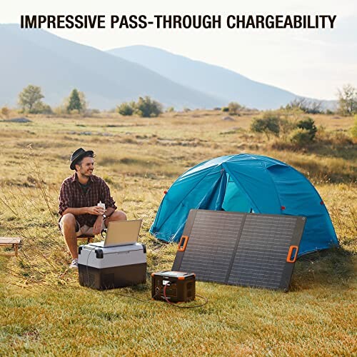 Man camping with solar panel and tent in field